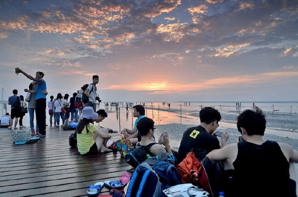 Cây cầu nổi bằng gỗ kéo dài từ bờ ra xa là điểm dừng chân quen thuộc của nhiều người khi thủy triều lên cao - Ảnh: Gaomei