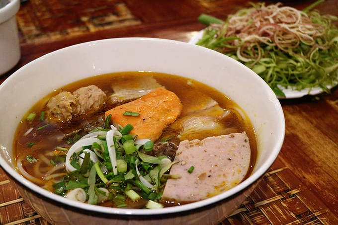 Tô bún bò lớn có giá 72.000 đồng, tô nhỏ giá 62.000 đồng. Món ăn sẽ không ngon nếu thiếu rau muống chẻ sợi, rau chuối bào, giá cọng. Bạn có thể yêu cầu rau trụng hoặc để sống tuỳ theo sở thích. Ảnh: @thehungrymoustache.