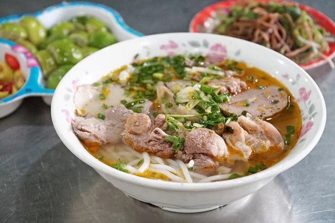 Bún bò Huế từng được đầu bếp lừng danh Anthony Bourdain công nhận là một trong những món ăn ngon nhất thế giới. Tô bún hấp dẫn với vị nước lèo đậm đà, cay, bên trong là thịt bò kèm giò heo, rau tươi. Món ăn có nguồn gốc từ Huế nhưng ở Sài Gòn, du khách vẫn có thể tìm thử tại 10 địa chỉ nổi tiếng dưới đây.  Bún bò 31  Tọa lạc trên đường Mạc Đĩnh Chi (quận 10), quán nổi bật nhờ bảng hiệu lớn có màu đỏ. Thoạt nhìn, không gian nơi này có thể trông hơi cũ vì nó đã tồn tại gần 30 năm. Tại đây, thực khách có thể gọi một