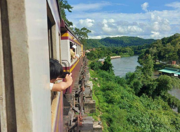 Du khách chụp ảnh qua cửa sổ tàu khi đi tour Phan Thiết bằng tàu hỏa