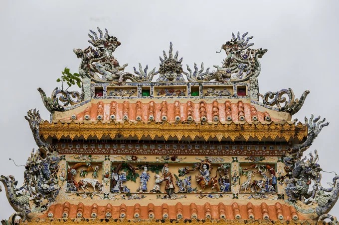 Trên tầng mái cổng tam quan được trang trí tinh xảo các tượng long, lân, quy, phượng, canh, mục, ngư tiều... Vật liệu bằng đồ sứ của Việt Nam, Trung Hoa với nước men xanh tạo nên màu sắc óng ánh. Trên tầng mái cổng tam quan được trang trí tinh xảo các tượng long, lân, quy, phượng, canh, mục, ngư tiều... Vật liệu bằng đồ sứ của Việt Nam, Trung Hoa với nước men xanh tạo nên màu sắc óng ánh.